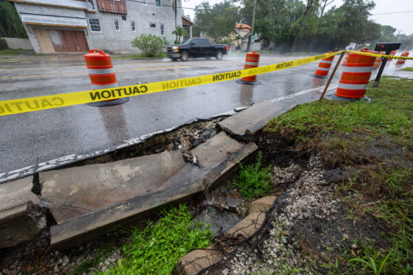 Photo by Jason Gulley/Wildpath. Stormwater pours into a sinkhole in the front yard of a homeowner near the intersection of South Manhattan Ave. and West Sevilia St. in Tampa, Florida during Hurricane Helene. Streets, homes and businesses along this stretch of South Manhattan Avenue flood during high intensity rainfall events because the stormwater drainage system in this part of the city is old and undersized (https://www.tampa.gov/project/sw50004).