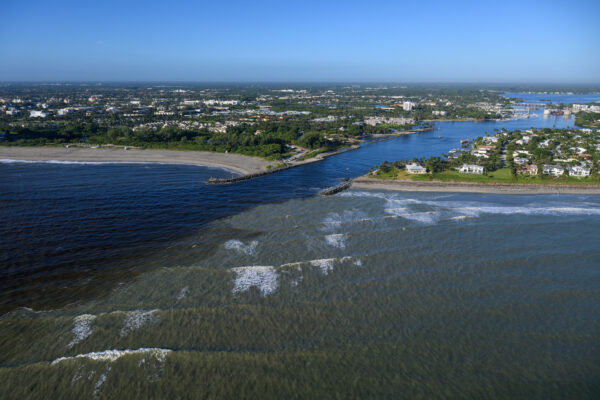Photo by Jason Gulley/Wildpath. Fresh, tannic water from the St. Lucie River pours through the Jupiter Inlet and collides with the Atlantic Ocean. Stormwater runoff from surrounding urban and agricultural areas flood the river with pollution following heavy rains.