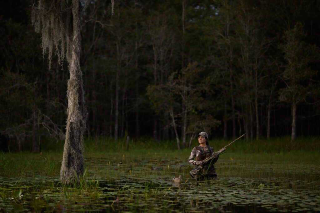 Photo by Jason Gulley/Wildpath. Tiffiny Sanders, an avid duck hunter, wades through a shallow wetland near Hawthorn, Fla.