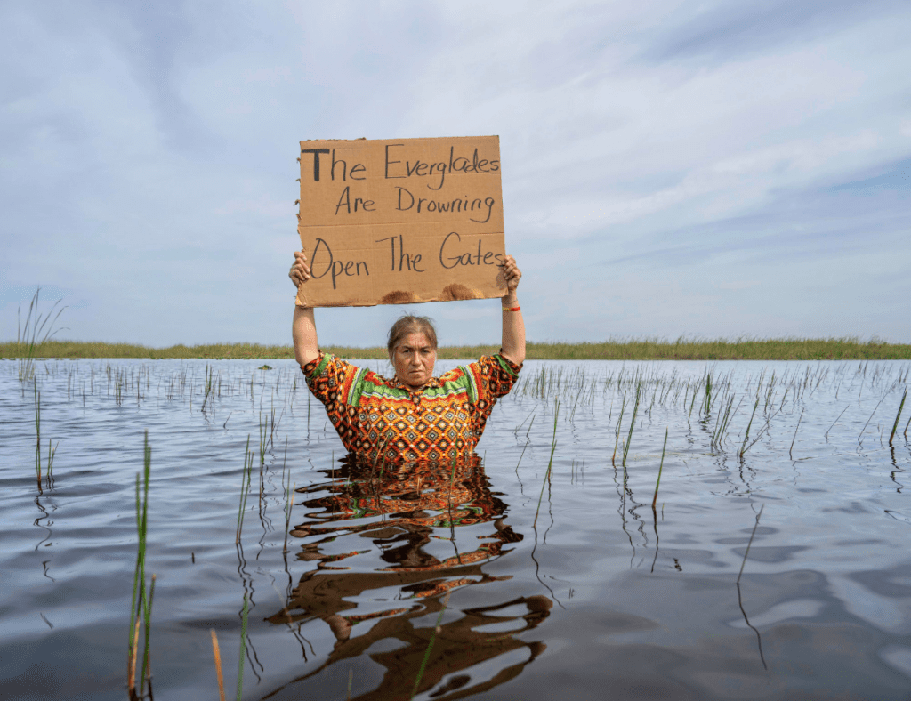 Betty Osceola in front of one of her favorite tree islands, chest deep in the Everglades. Photographed by Carlton Ward Jr.